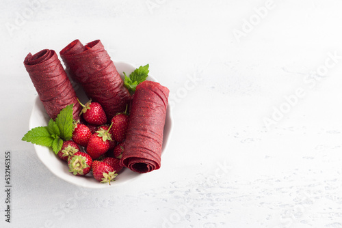 Homemade strawberry pastille with fresh strawberries on a light blue background