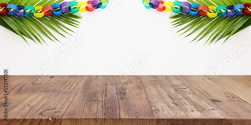 Jewish festival of Sukkot. Traditional succah (hut) with decorations. Empty wooden old table for product display and presentation. photo