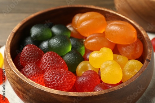 Delicious gummy candies in wooden bowl  closeup