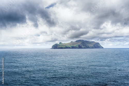 Beautiful island in the sea. Dramatic storm clouds in the sky. Seascape. Faroe islands. Denmark. photo