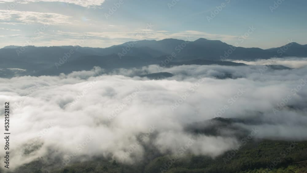 mountain hills covered with white dense clouds above at bright sunny day mountain hills covered with white dense clouds above at bright sunny day