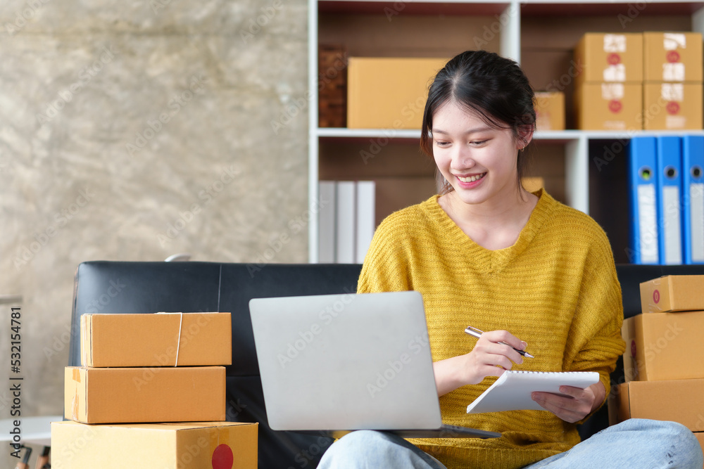Beautiful Asian online business owner is preparing a parcel box to prepare the package for delivery to the customer. Check the list of items and the shipping address is correct. Beautiful Asian online business owner is preparing a parcel box to prepare the package for delivery to the customer. Check the list of items and the shipping address is correct.