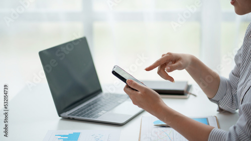 Close-up of a woman using a smartphone to work on various social media applications. including mobile transactions and LINE messaging and other business information via LINE.