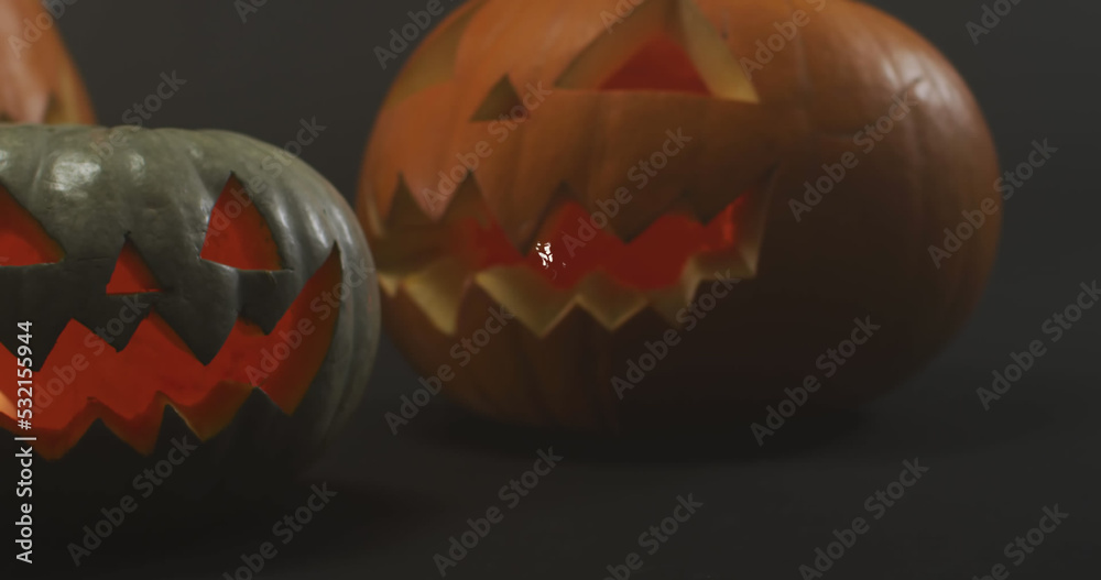 Fototapeta premium Image of halloween text over carved pumpkins on grey background