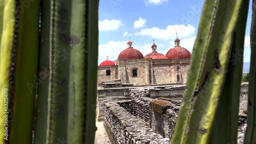 Ancient Ruins Site of Mitla Oaxaca Mexico, Close Up Dolly View Through Cactus Plant of Stone Ruins Walls and Old Architectural Church Religious Monument in Background, Archeological Tourist Site photo