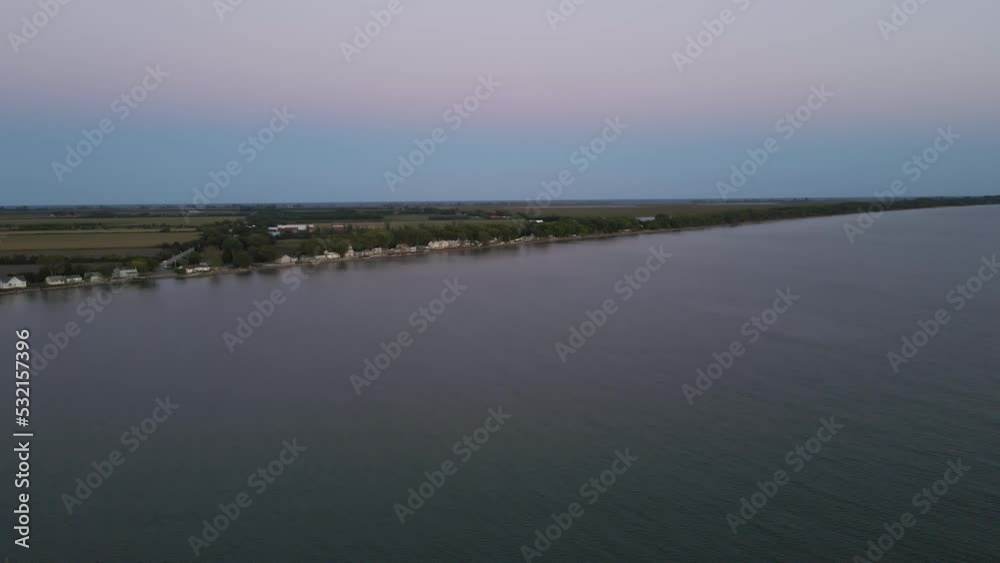 Wide angle establishing aerial shot flat long coastline with sea and ocean