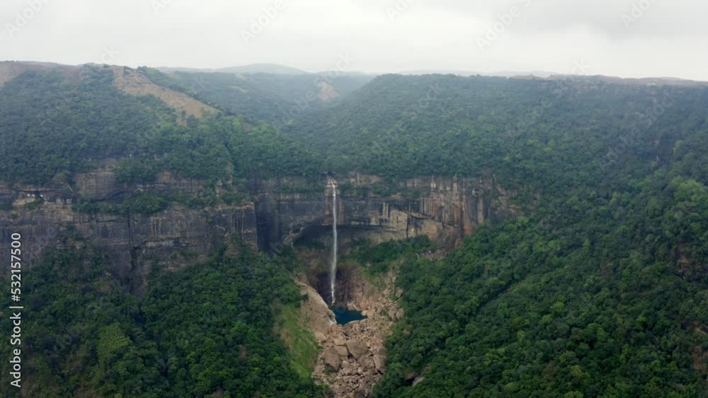 Nohkalikai Waterfall Falling From Mountain Cliff With Green Forest In Meghalaya, India. - aerial Nohkalikai Waterfall Falling From Mountain Cliff With Green Forest In Meghalaya, India. - aerial