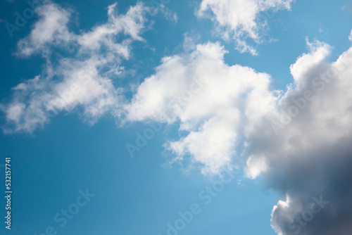 White, fluffy clouds in blue sky. Background from cumulus clouds. Scenery above the clouds