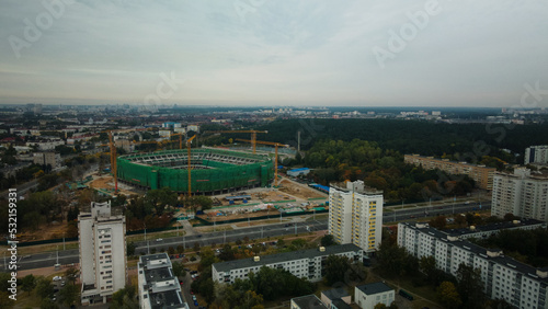 Building a stadium in a big city. Construction site among urban areas. Aerial photography.