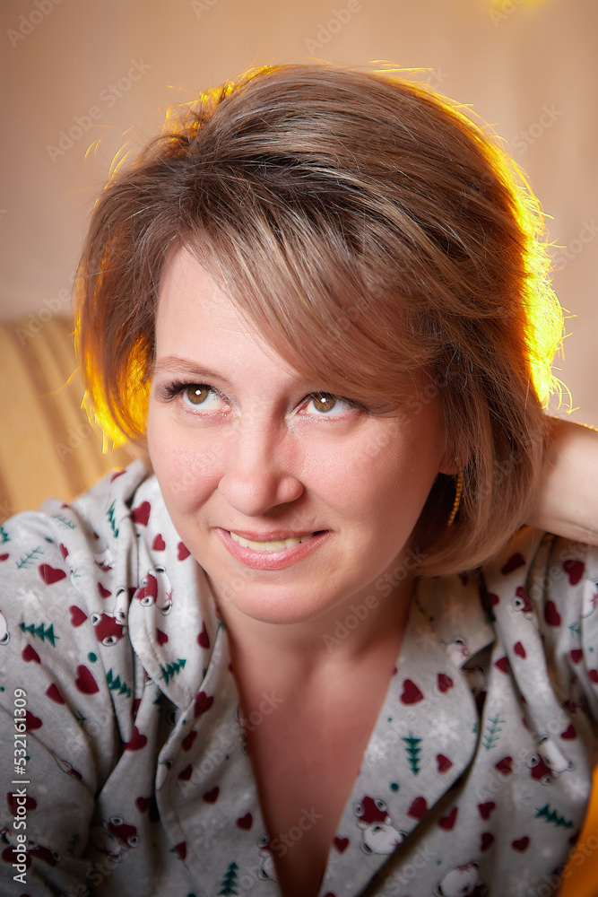 Happy adult middle aged woman wearing pajamas in room with Christmas decorations. New Year holiday in Russia Happy adult middle aged woman wearing pajamas in room with Christmas decorations. New Year holiday in Russia