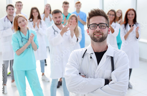 confident doctor standing in front of a group of medical professionals