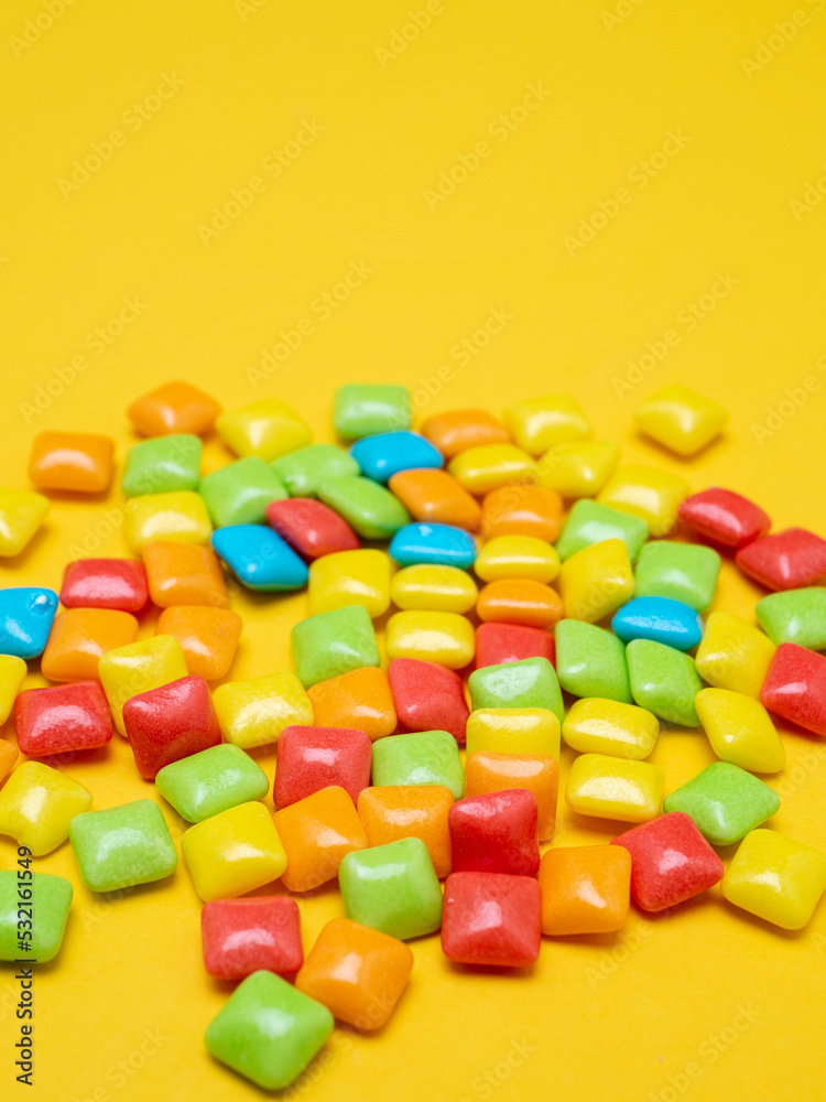Multicolored marmalade sweets on a yellow background. Place for text