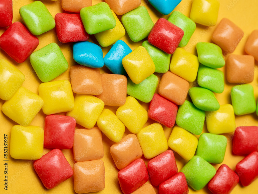 Multicolored marmalade sweets on a yellow background.
