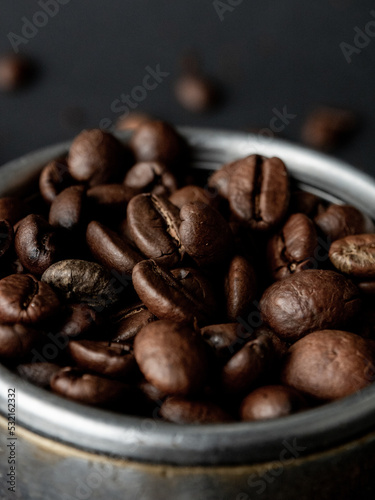 Coffee beans in a holder on a black background