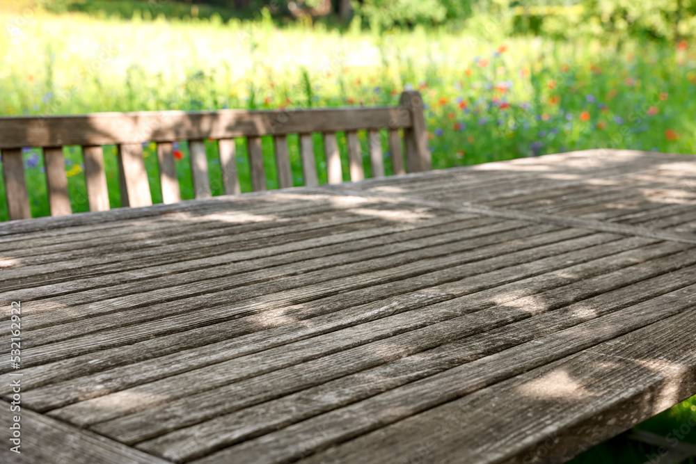 Empty wooden table with bench on sunny day in garden Empty wooden table with bench on sunny day in garden