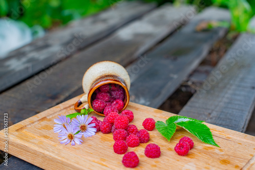 raspberries in a glass and a handful of raspberries and flowers of the Novobelgian Aster. High quality photo photo