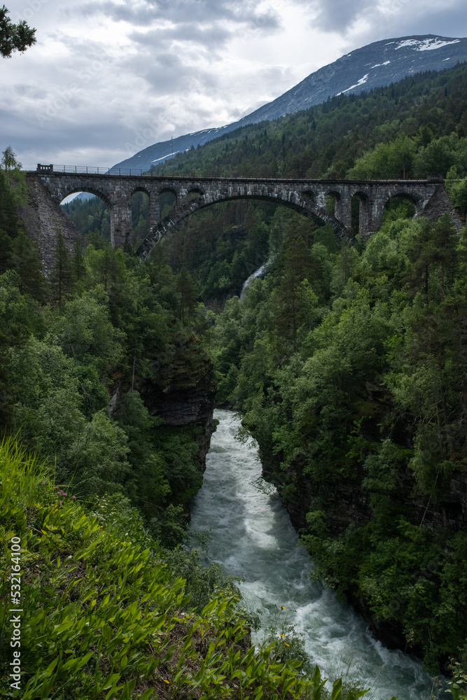Overdalen, Norway - July 01, 2022: Kylling Bru is a railway bridge that is in hand-hewn stone. The Rauma line crosses the bridge in Verma, at the top of Romsdalen. Selective focus.