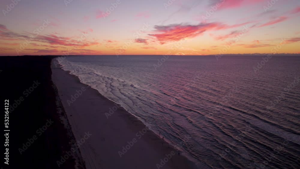 Aerial view of beautiful beach in Krynica Morska during golden sunset at horizon - Tranquil waves of Baltic Sea reaching shoreline Aerial view of beautiful beach in Krynica Morska during golden sunset at horizon - Tranquil waves of Baltic Sea reaching shoreline