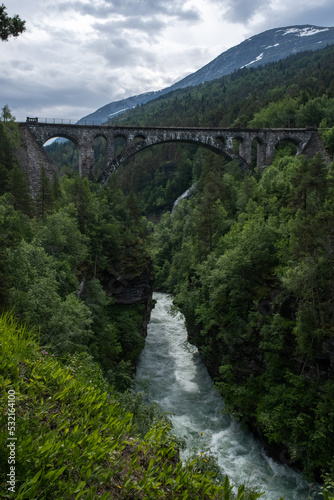 Overdalen, Norway - July 01, 2022: Kylling Bru is a railway bridge that is in hand-hewn stone. The Rauma line crosses the bridge in Verma, at the top of Romsdalen. Selective focus. photo