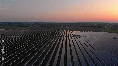 Aerial drone view into large solar panels at a solar farm at summer sunset. Solar cell power plants. footage video 4k.