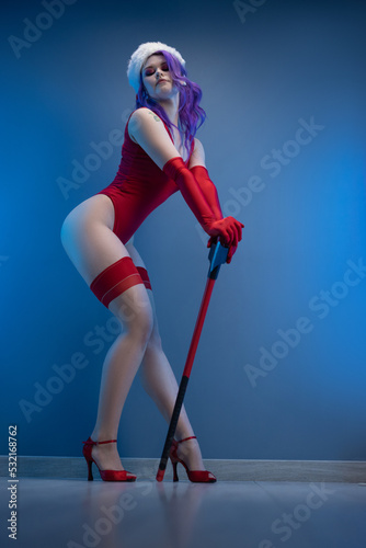 sexy girl in red underwear and santa hat with an axe on a blue background