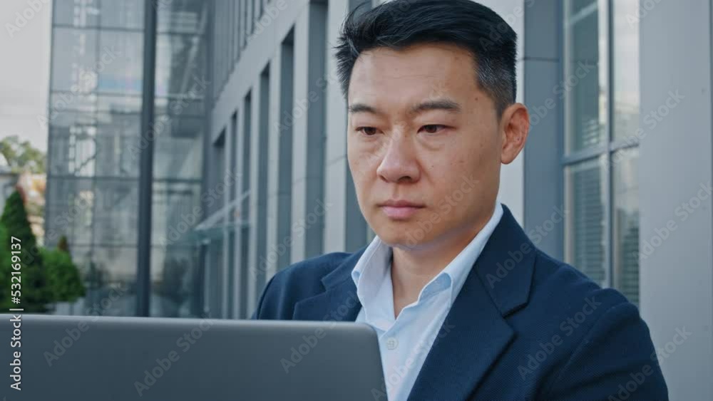 Close up Asian 40s middle-aged businessman entrepreneur employer man worker manager boss designer financial analyst working with computer typing laptop remote job online web project in city outdoors Close up Asian 40s middle-aged businessman entrepreneur employer man worker manager boss designer financial analyst working with computer typing laptop remote job online web project in city outdoors