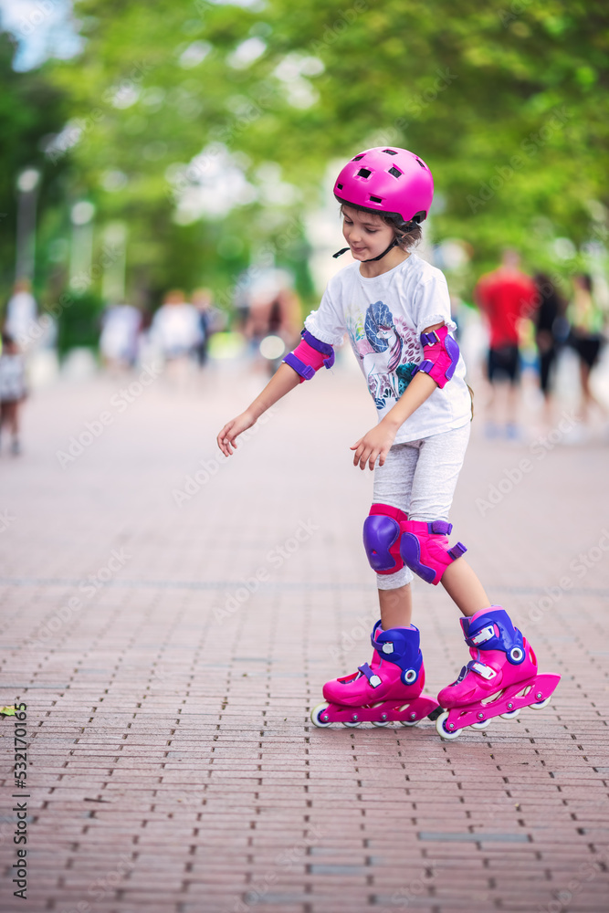 Little girl riding roller skates on the city playground.  Woman on roller blades.