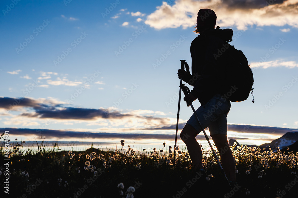 Hiker with backpack enjoying the view with sunset sky background