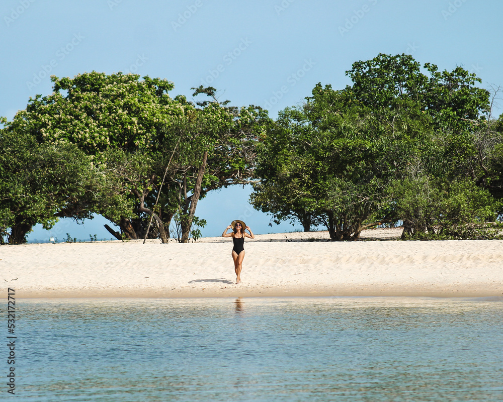 Obraz premium Mulher caminhando nas margens do rio Tapajós. Praia de Cajutuba, Belterra, Pará