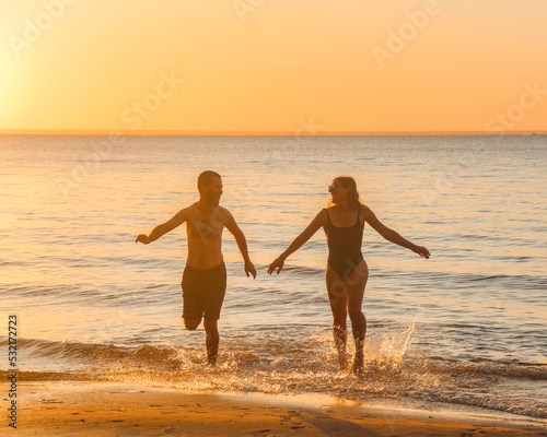 Casal correndo na praia durante por do sol em Belterra, Pará, no rio Tapajós