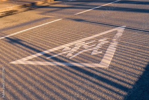 Old running children white sign on road asphalt with fence shadow