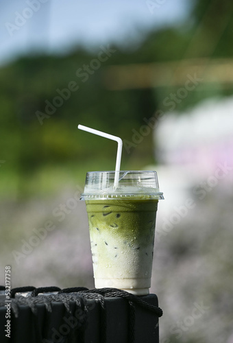 Ice green matcha Latte Tea in Plastic glass on Blur natural Background photo