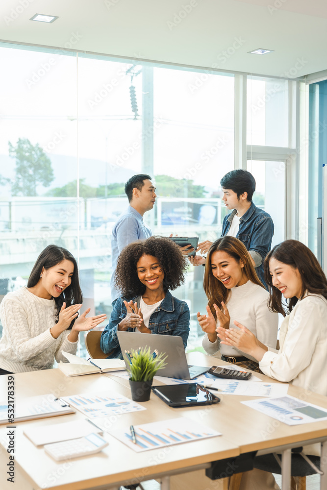 Young and successful mixed race, asian business people working on project together, sitting at table in boardroom. Young and successful mixed race, asian business people working on project together, sitting at table in boardroom.