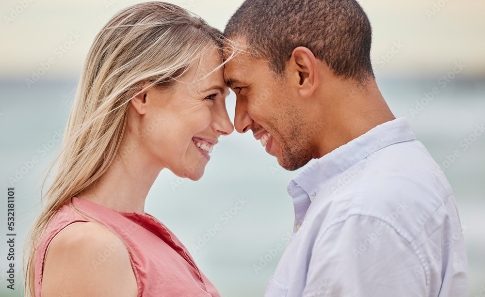 Portrait of couple at the beach with their forehead touching. Multiracial man and woman in relationship, happy, smiling and in love on vacation. Bonding, love and quality time together Portrait of couple at the beach with their forehead touching. Multiracial man and woman in relationship, happy, smiling and in love on vacation. Bonding, love and quality time together