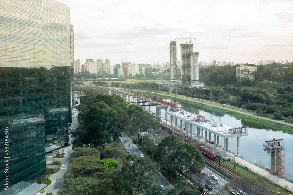 Fototapeta premium Beautiful view of São Paulo city skyline, modern buildings, Marginal Pinheiros avenue and river. Corporate towers and viaduct under construction. Concept of cityscape, urban, travel, architecture.