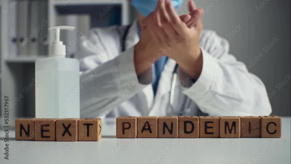 Phrase new pandemic is assembled on table from wooden cubes. Rules, recommendations during pandemic. Doctor disinfects hands on background of words from cubes. Hand disinfection way stop spread virus Phrase new pandemic is assembled on table from wooden cubes. Rules, recommendations during pandemic. Doctor disinfects hands on background of words from cubes. Hand disinfection way stop spread virus