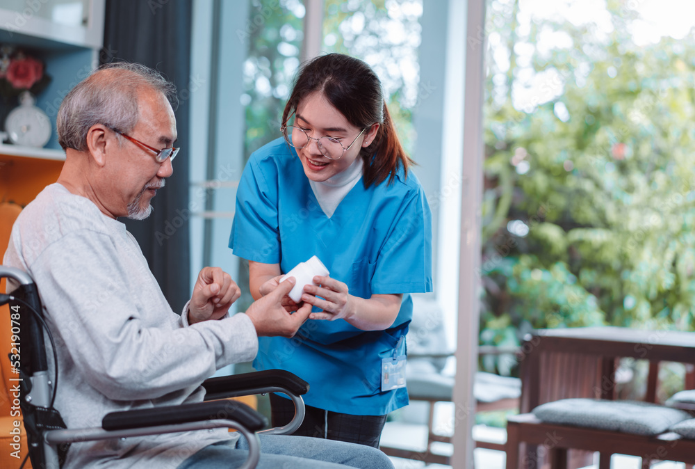 Obraz premium Asian senior male patient consult prescription drug with physician nurse at nursing home. Caregiver therapist pharmacist woman hold medicine pills bottle, medicine dosage at house in living room.