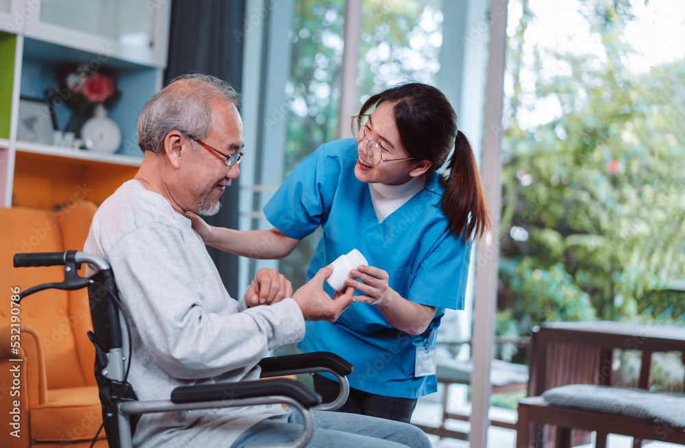 Fototapeta premium Asian senior male patient consult prescription drug with physician nurse at nursing home. Caregiver therapist pharmacist woman hold medicine pills bottle, medicine dosage at house in living room.