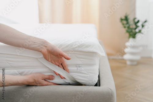Φωτογραφία Woman change waterproof bedding topper on orthopedic mattress