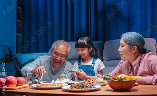 Asian happy family having lunch on dinner japanese table smiling together. little kid daughter enjoy eating food grandparents. Happiness time people lifestyle concept.