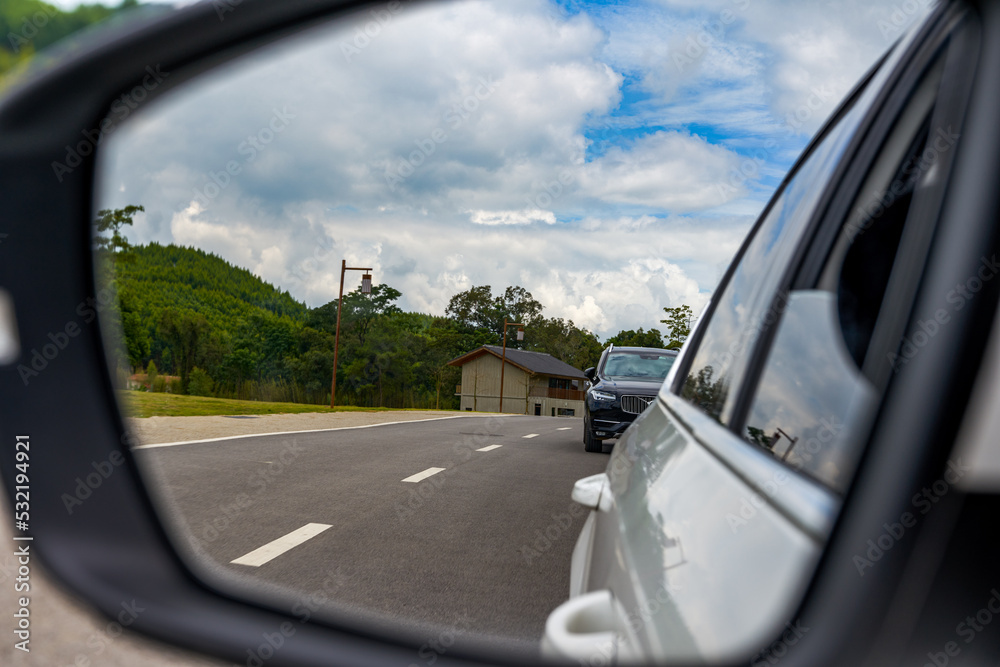 Beautiful view of blue sky and white clouds from car rearview mirror