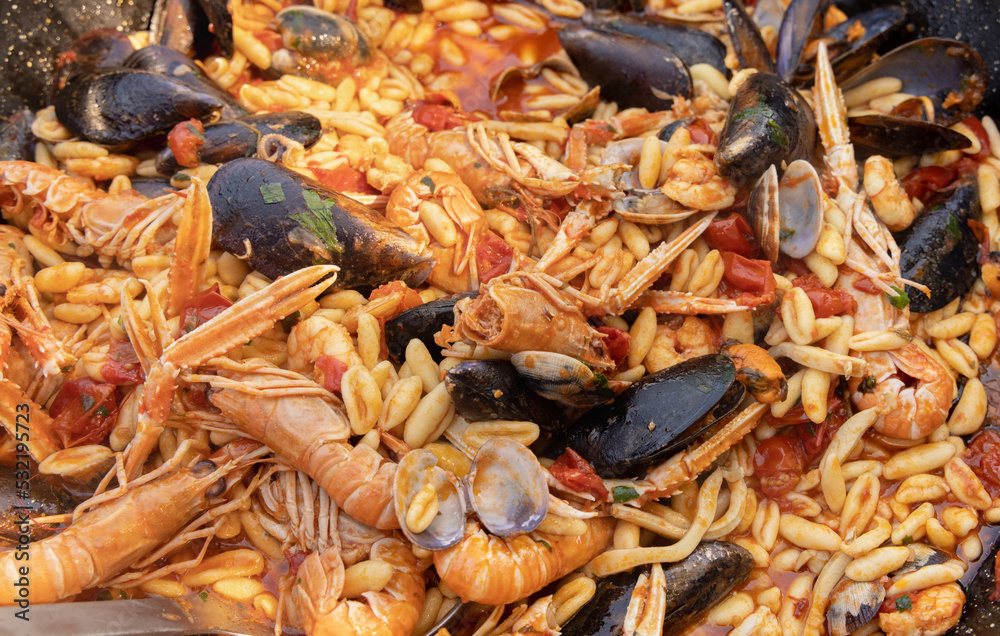 Italian Cavatelli allo scoglio, pasta with seafood and tomatoes close up in a frying pan Italian Cavatelli allo scoglio, pasta with seafood and tomatoes close up in a frying pan