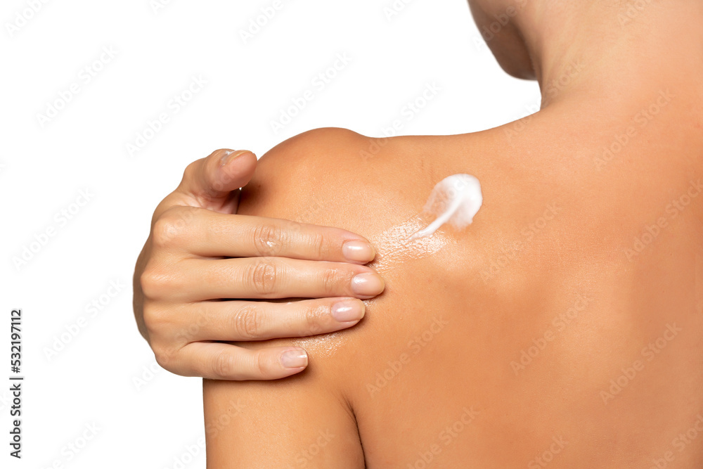 Fototapeta premium Close up young woman smearing shoulder with cream. Back view