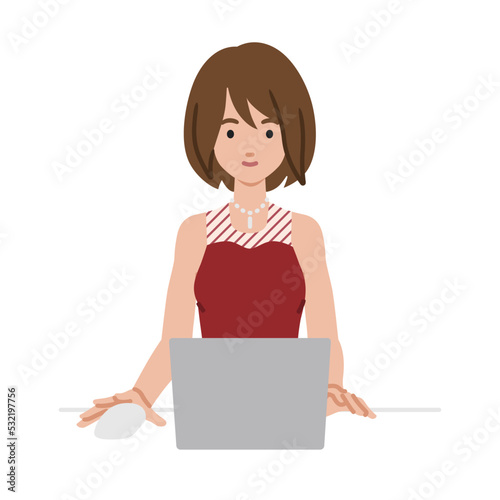 デスクで座ってPCを使っているドレスの女性