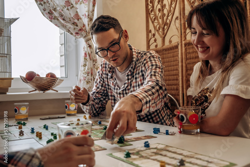 A group of young people play board games at home in the kitchen.Time together.Stay home,board games concept.Selective focus. photo