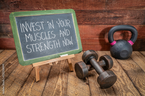 Fototapeta Naklejka Na Ścianę i Meble -  invest in your muscles and strength nowinvest in your muscles and strength now - motivational text on a blackboard with dumbbells and kettlebell, health and fitness concept
