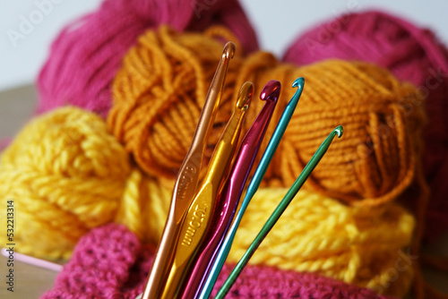 Colorful crotchet hooks with woolen background