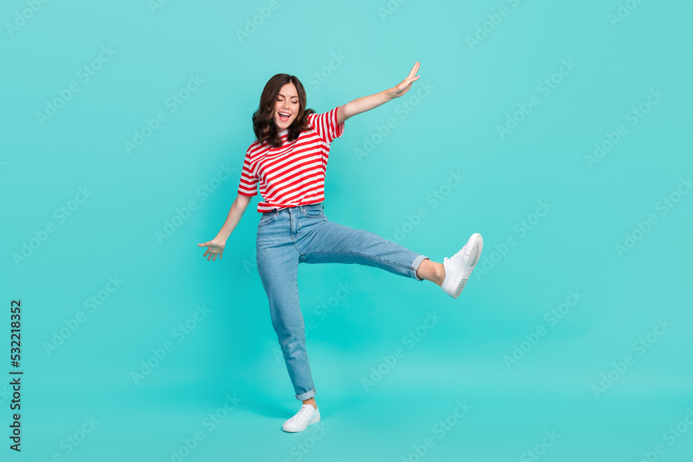 Full length photo of funky charming lady wear striped t-shirt dancing having fun smiling isolated turquoise color background
