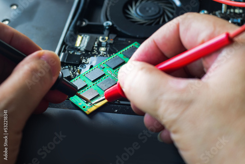 repair, Computer repair technicians, technicians, notebook repair. Use a tool to measure the point of damage on the laptop's RAM chip.