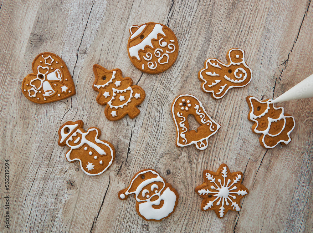 Close up of drawing gingerbread Christmas snowflake sugar cookie on wooden table background with white icing Close up of drawing gingerbread Christmas snowflake sugar cookie on wooden table background with white icing